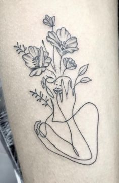 a woman's thigh with flowers on it and the outline of her hand in front