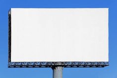 a large white billboard on top of a metal pole