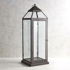 an old - fashioned lantern stands on a white floor in front of a textured wall