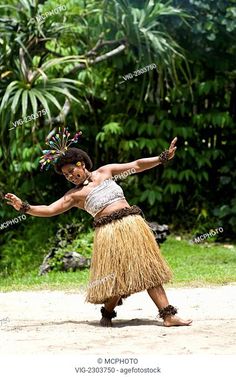 a woman in traditional dance attire dancing on the ground with her arms outstretched and legs spread out