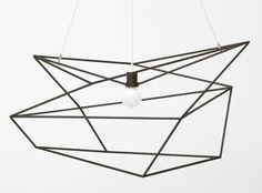 a light hanging from a ceiling fixture with a white ball in the center and black wire around it