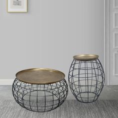 two metal vases sitting next to each other on top of a carpeted floor