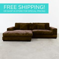 a large brown couch sitting on top of a white floor next to a blue sign that says free shipping or shop in store for special pricing