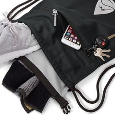 a cell phone and keys in a black bag on top of a pair of gloves