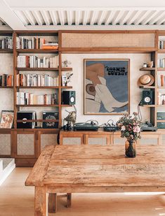 a wooden table sitting in front of a book shelf filled with books