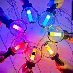 a group of people holding magnifying glasses in the shape of a circle with lights on them