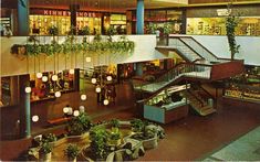 the inside of a shopping mall with plants hanging from it's balconies