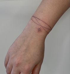 a woman's hand with a small star tattoo on the left side of her wrist