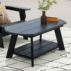 two chairs and a table on a rug with a potted plant next to it