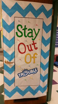 a sign that says stay out of trouble on the front of a door with blue and white chevrons