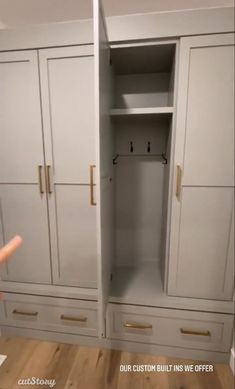 an empty closet with drawers and shelves in the corner, next to a child's hand pointing at it