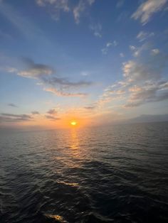 the sun is setting over the ocean as seen from a boat