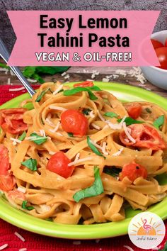 a green plate topped with pasta and tomatoes