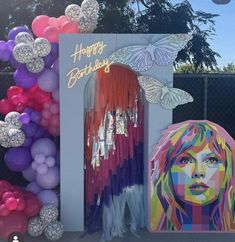 a birthday party with balloons, streamers and decorations on the side of a fence