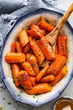 roasted carrots in a bowl with a wooden spoon