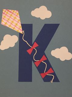 the letter k is made up of kites in the sky with clouds behind it