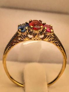 "Very unique handmade gold ring with real gamstones . 14k gold antique victorian ring with a real garnet stones in the middele + 1 real beautiful ruby in the side + one real beautiful sapphire on the other side . Hand made by myself Weight : about 1.9 gram Central stone : garnet 4/6 m\"m Ruby stone : 3/5 mm Sapphire stone : 3/5 mm" Elegant Yellow Gold Ruby Ring With Intricate Design, Antique 14k Gold Ruby Ring With Multi-stone, Red Multi-stone Sapphire Ring, Fine Jewelry Yellow Gold Ruby Ring With Intricate Design, Antique Yellow Gold Sapphire Ring With Round Cut, Elegant Three-stone Birthstone Ring In 14k Gold, Elegant Three Stone Birthstone Ring In 14k Gold, Antique Multi-stone Yellow Gold Jewelry, Antique Yellow Gold Multi-stone Jewelry