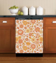 a dishwasher sitting on top of a kitchen counter next to a bowl of fruit