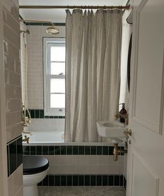 a white toilet sitting next to a bath tub in a bathroom under a shower curtain