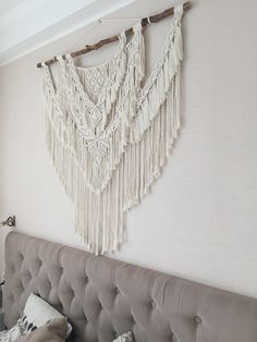 the headboard of a bed with macrame hanging on it's wall