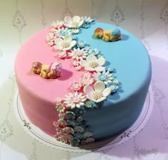 there is a blue and pink cake with flowers on it