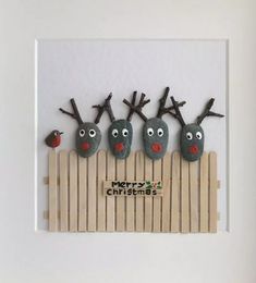 three reindeers on a fence made out of rocks and wood sticks with the words merry christmas