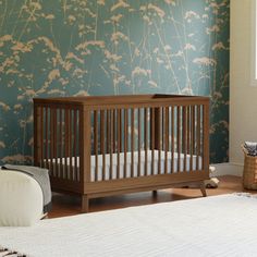 a baby crib in a room with blue wallpaper