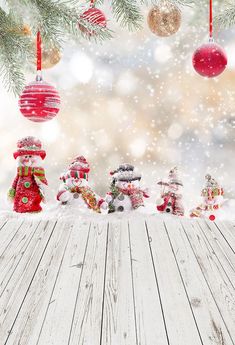 a wooden table topped with snow covered christmas ornaments