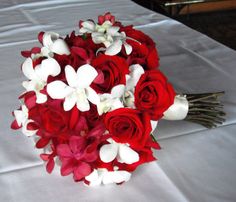 a bouquet of red and white flowers on a table