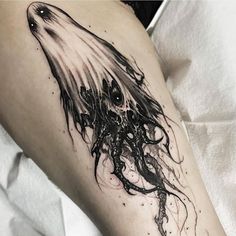 a black and white photo of an octopus tattoo on the leg, with ink splatters all over it