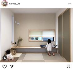 two children are sitting on the floor in a room with white walls and beige floors