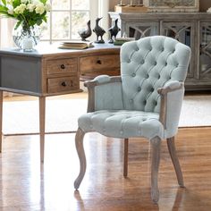 a blue chair sitting on top of a hard wood floor next to a wooden desk