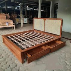 a wooden bed frame with drawers on the bottom