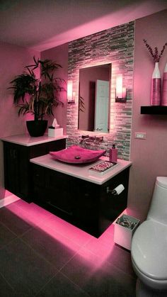 a bathroom with pink lighting in it