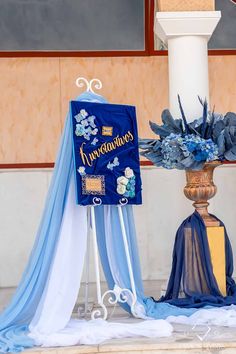 a blue and white wedding arch with flowers on it