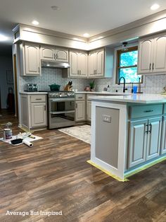 a kitchen with white cabinets and an island in the middle is being remodeled to look like it has been painted