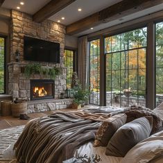 a bedroom with stone fireplace and large windows