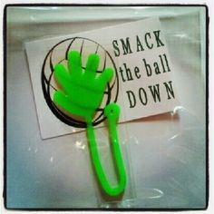 a green plastic object sitting on top of a white table next to a sign that says smack the ball down