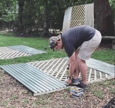 a man kneeling down on top of a metal grate