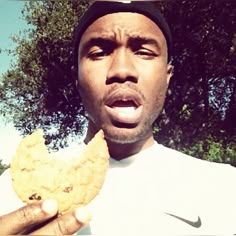 a man holding up a cookie in front of his face