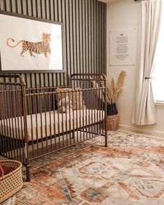 a baby's room with a crib, rug and pictures on the wall