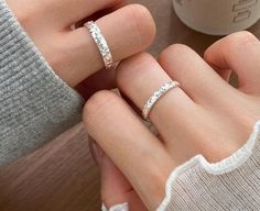 two women's hands holding each other with their wedding rings on top of them