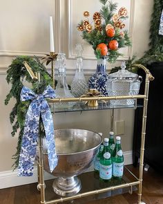 a bar cart decorated with christmas decorations and bottles of booze for the holiday season