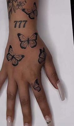 a woman's hand with butterflies on it and the number 17 tattooed on her wrist