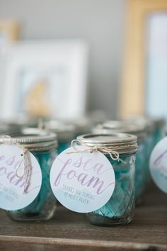 mason jars with labels on them sitting on a table