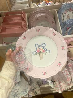 there is a pink and white plate with a bow on it next to other plates