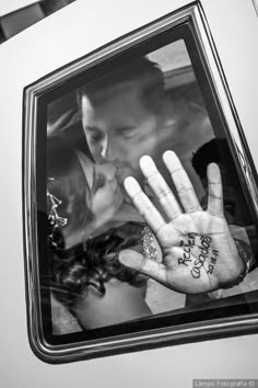 a man and woman kissing in the back seat of a car with their hand written on it