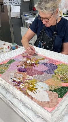 a woman is working on an art piece