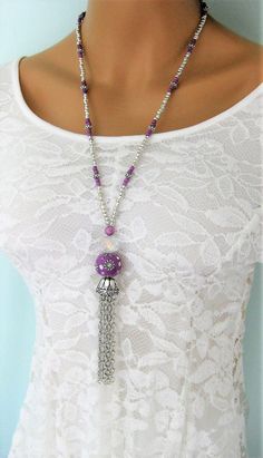 Long Silver and Purple Beaded Necklaces with Tassel handmade by Ralston Originals. These beaded necklaces come in your choice of Styles. I made the first purple tassel necklace (pictures 1 - 4) with a large purple crackle glass bead, a large antique silver metal bead on top of it, followed by a blue ceramic bead with antique silver metal bead caps surrounding it. The beaded chain is made with silver seed beads, purple seed beads, and a purple and blue bead. I made the tassel with silver metal ch Bohemian Long Tassel Necklace For Party, Bohemian Purple Beaded Necklace With Dangling Beads, Bohemian Beaded Dangle Tassel Necklace, Bohemian Tassel Necklace With Beaded Chain, Beaded Tassel Necklace, Blue Beaded Necklace, Assemblage Necklace, Purple Necklace, Steampunk Necklace