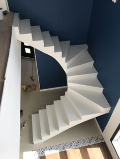 an overhead view of a spiral staircase in a house with blue walls and wood flooring